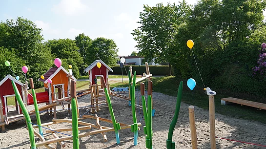 Spielplatz mit Spielhäusern, Balancier- und Kletterelementen.